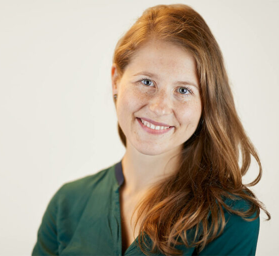 Melanie Lubbe Portrait mit Blick in die Kamera, grünes Oberteil.