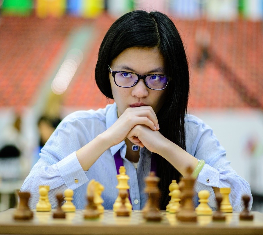 Schachspielerin Hou Yifan vor einem Schachbrett.